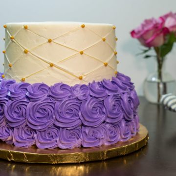 This two-tier cake features purple butter cream "dress" on the bottom and a quilted butter cream on top.